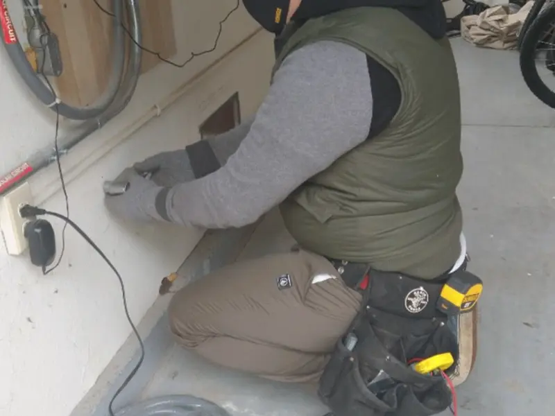 Electrician performing outlet wiring in a Bristol garage